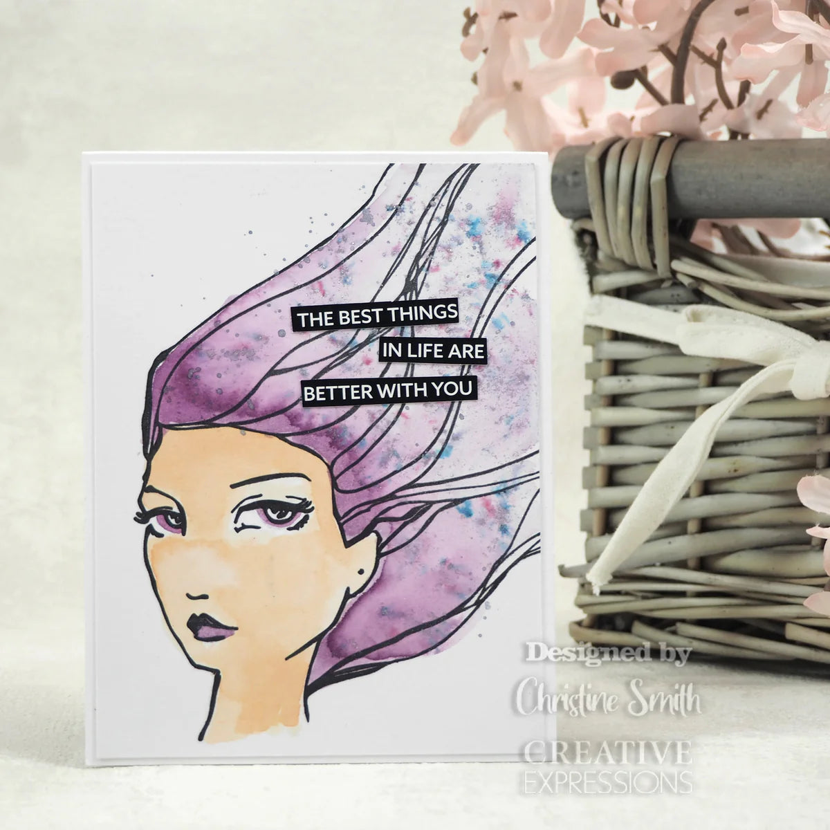 Card with a stylized face and text 'The best things in life are better with you' next to a wicker basket.