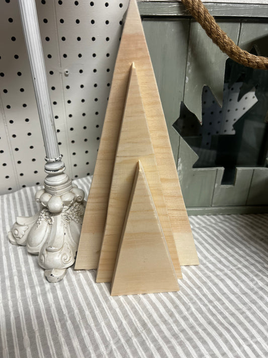 Two wooden triangle blocks on a striped surface with a decorative item in the background.